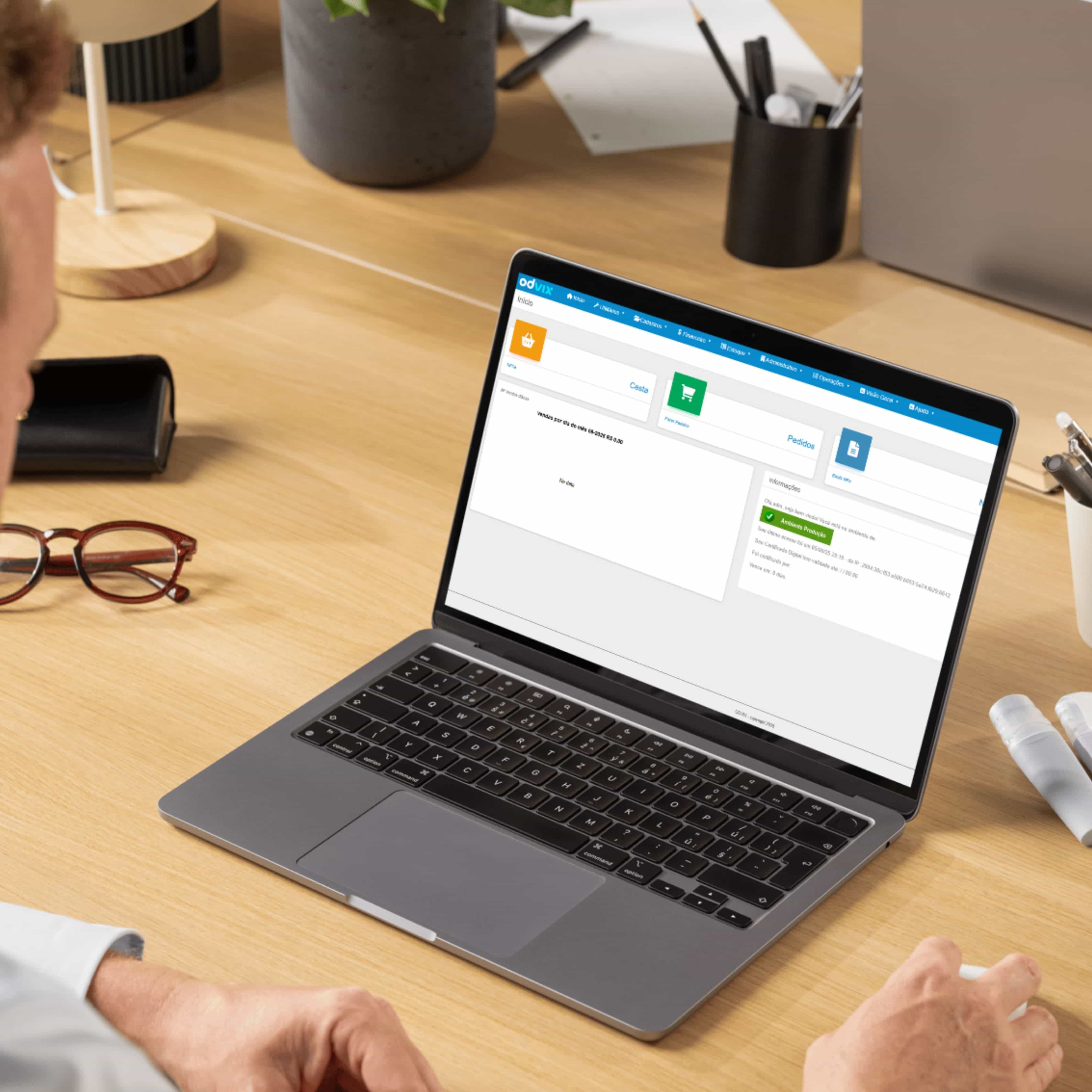 Homem utilizando sistema de gestão Odvix no notebook